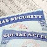 Social Security ID cards with a financial spreadsheet behind them.