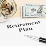 Money sitting beside a retirement plan document